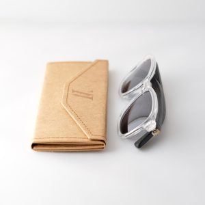 Bamboo sunglasses folded on white background, white frames, grey lenses and black arms.