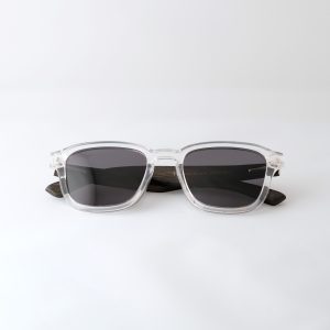 Bamboo sunglasses folded on white background, white frames, grey lenses and black arms.