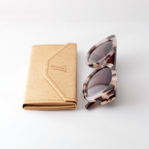 Bucharest Sunrise bamboo sunglasses folded with folded case, on a white background. They have brown lenses, tortoise frame and brown arms