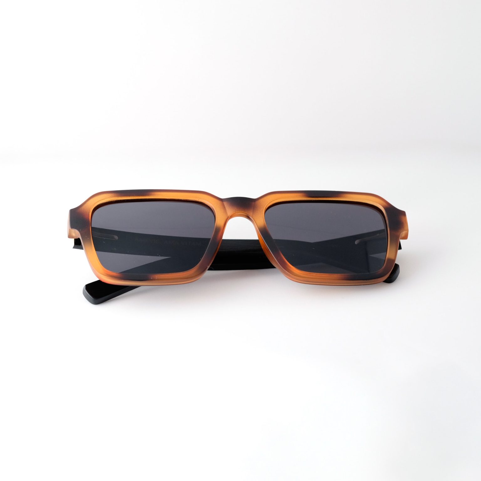 Carpatia bamboo sunglasses, folded, on a white background. tortie frames, dark lenses.