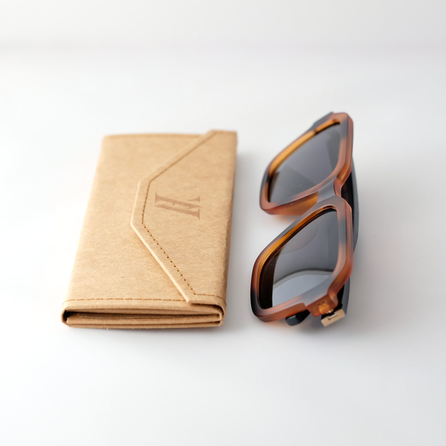 Carpatia bamboo sunglasses, folded, on a white background. tortie frames, dark lenses.